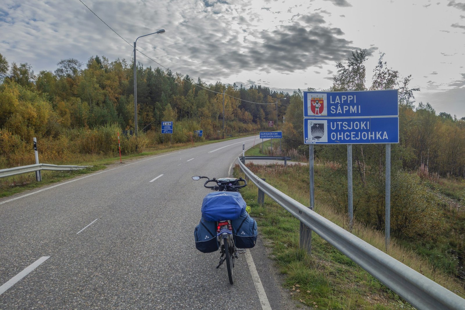 a bicycle parked on the side of a road next to a sign